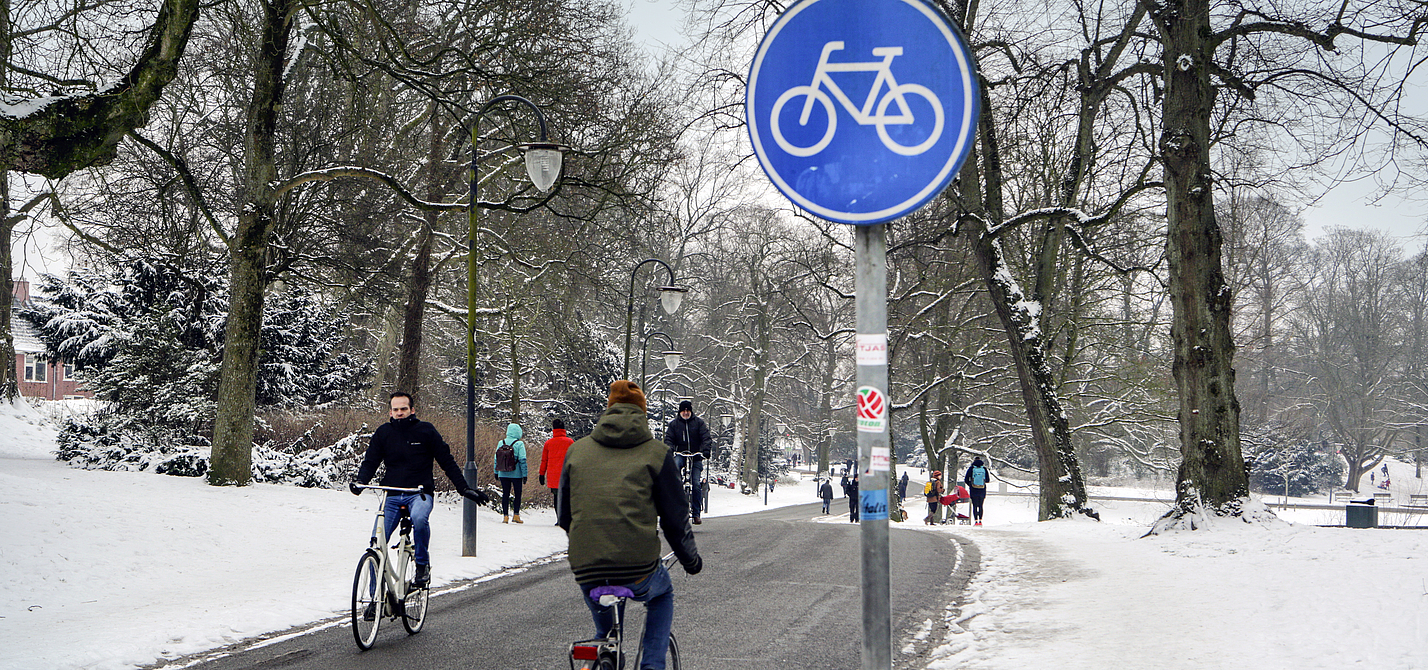 Winterlicher Fahrradweg in Groningen Radfahrer auf geräumten Radweg in Groningen
