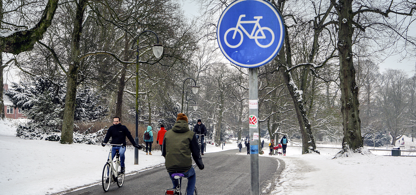 Winterlicher Fahrradweg in Groningen Radfahrer auf geräumten Radweg in Groningen