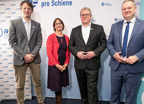Vier Personen stehen vor hellem Hintergrund: Wasilis von Rauch, Geschäftsführer Zukunft Fahrrad, Ann-Kathrin Schneider, ADFC-Bundesgeschäftsführerin, Dirk Flege, Geschäftsführer der Allianz pro Schiene und Burkhard Stork, Geschäftsführer des Zweirad-Industrie-Verbands (v.l.n.r.).  