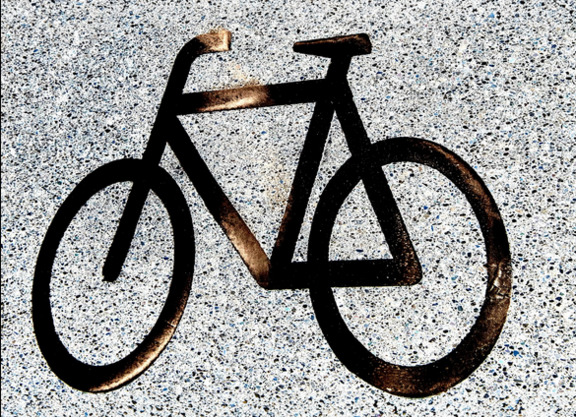 Ein schwarzes Fahrrad-Piktogramm auf Asphalt. 
