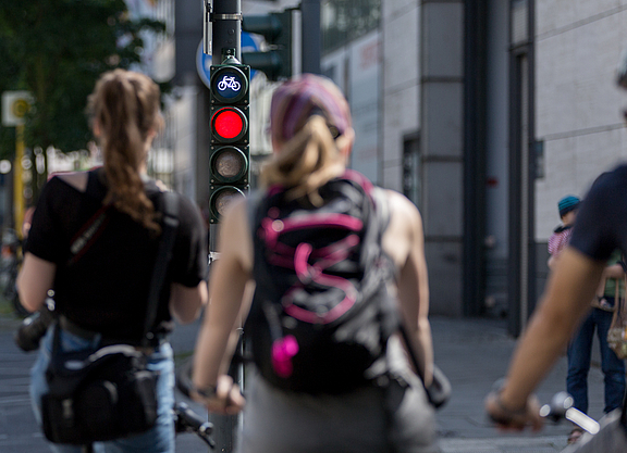 Radfahrende warten vor einer roten Ampel.