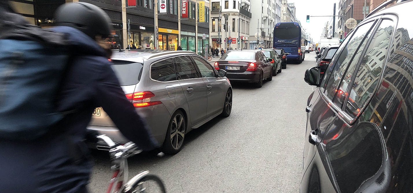 Radfahrer zwischen Autos ohne eigenen Radweg