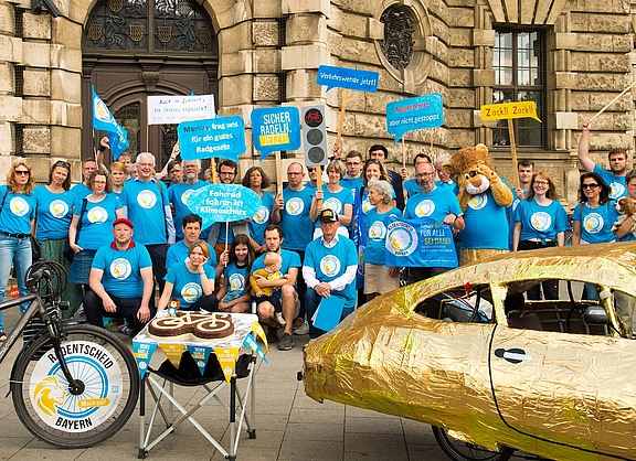 Eine Gruppe Radentscheid-Aktivist:innen vor dem Bayerischen Verfassungsgerichts-Gebäude in blauen T-Shirts. 