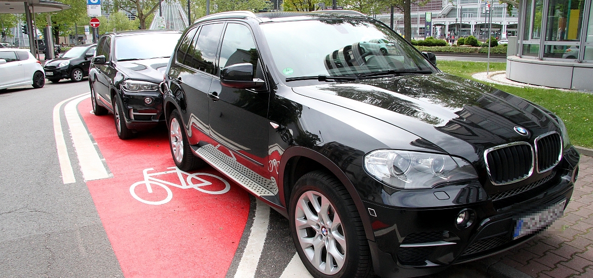 Schwarzer SUV parkt auf rot markiertem Radfahrstreifen