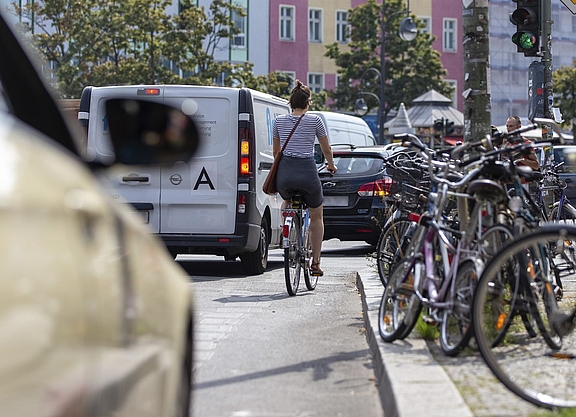 Radfahrerin auf Fahrbahn, bedrängt von Kfz.