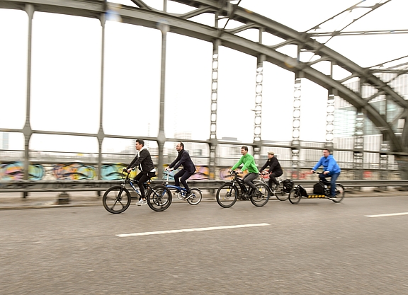 Mehrere Radfahrer fahren über eine Brücke.