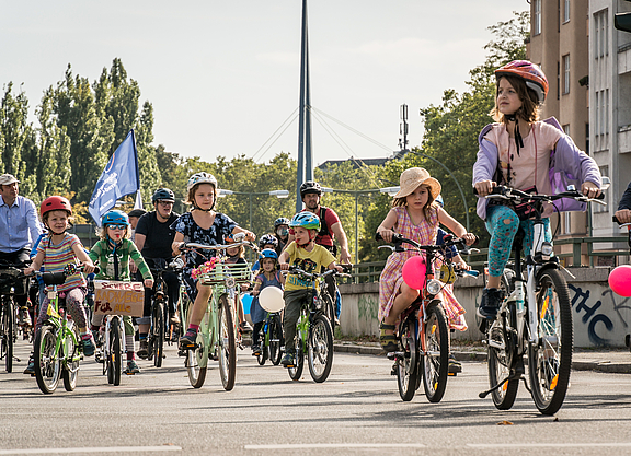 zahlreiche Kinder auf Fahrrädern mit Luftballons und Fahnen in Berlin